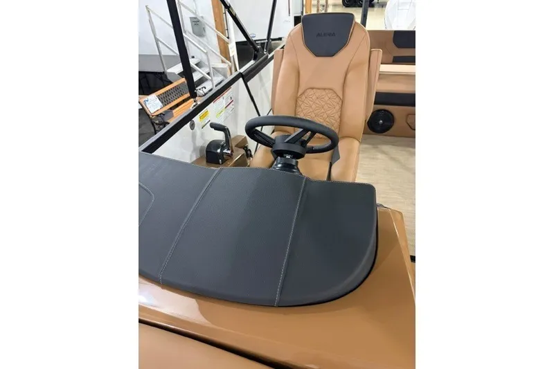 Slide: The Image of 2027 Alera M23L boat interior with tan leather seating and steering wheel. - 11