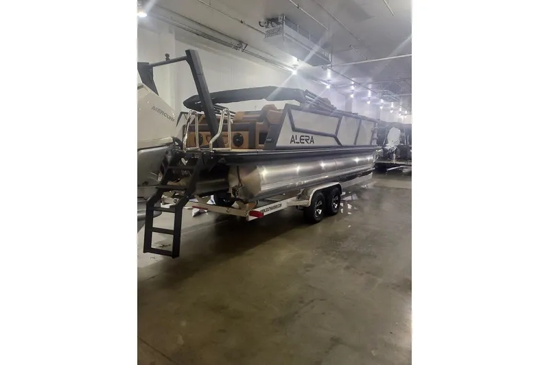 Slide: The Image of 2027 Alera M23L pontoon boat in a well-lit indoor showroom. - 3