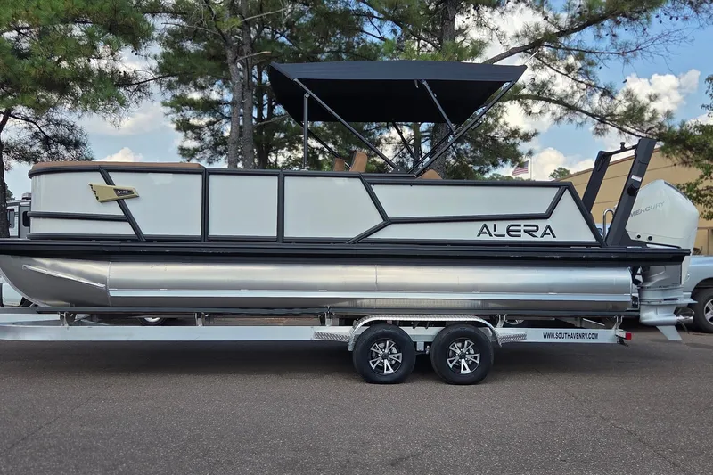 The Image of 2027 Alera M23L pontoon boat on trailer, parked outdoors with trees in background. - 1