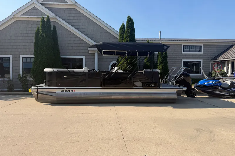 The Image of 2025 Crest Classic 220 pontoon boat parked outside a building on a sunny day. - 0