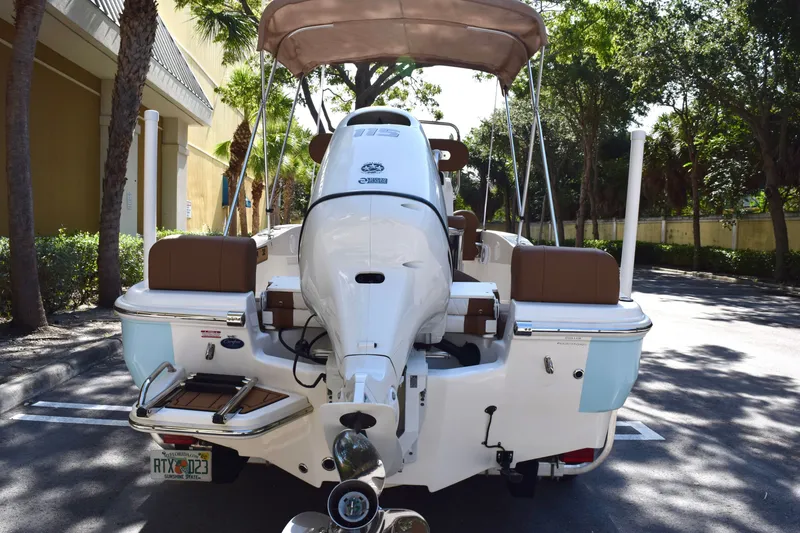 Slide: The Image of 2025 Pioneer 180 Islander boat, rear view, parked outdoors with canopy and motor visible. - 3