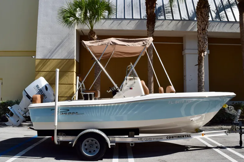 The Image of 2025 Pioneer 180 Islander boat on trailer, parked outdoors with palm trees. - 0