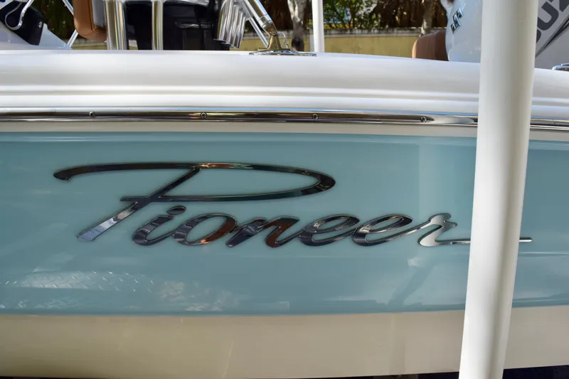 Slide: The Image of 2025 Pioneer 180 Islander boat with sleek logo on light blue hull. - 13