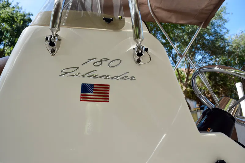 Slide: The Image of 2025 Pioneer 180 Islander boat console with American flag emblem. - 11