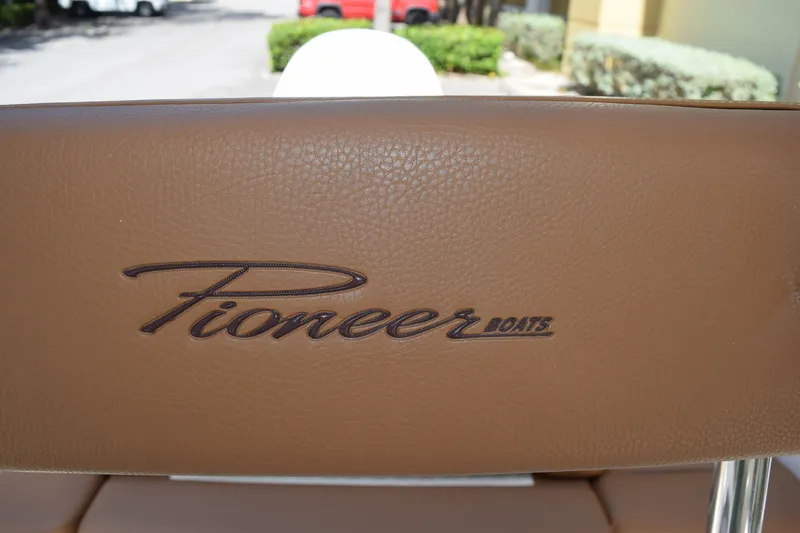 Slide: The Image of Brown leather seat with "Pioneer Boats" logo on a 2025 Pioneer 180 Islander. - 14