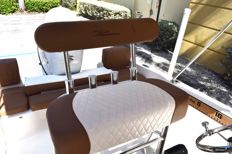 Slide: The Image of The image shows the seating area of a 2025 Pioneer 180 Islander boat with brown and white upholstery. - 9