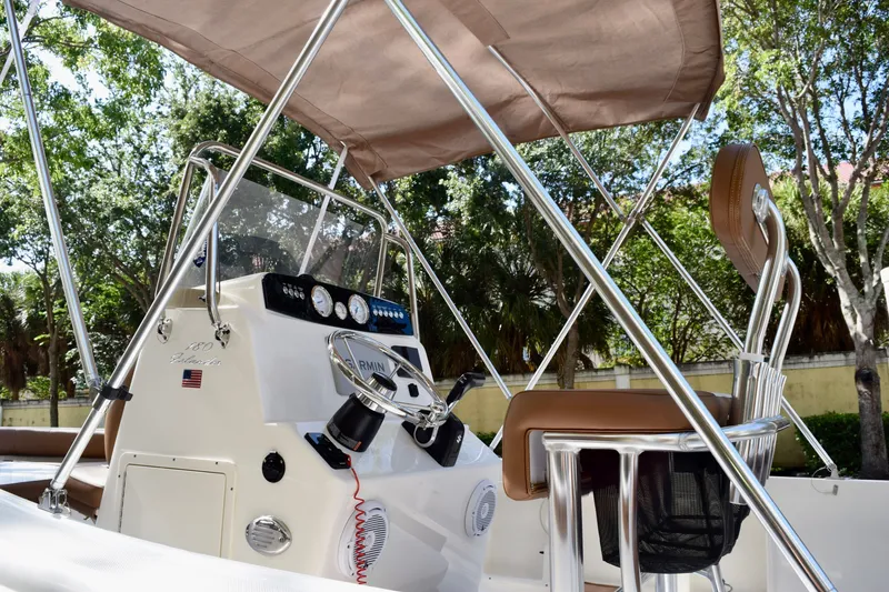 Slide: The Image of 2025 Pioneer 180 Islander boat interior with steering console and canopy. - 6