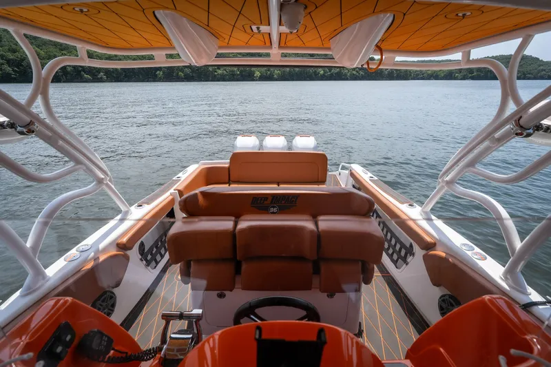 Slide: The Image of Interior view of a 2007 Deep Impact 360 C boat with orange seating and lake backdrop. - 23