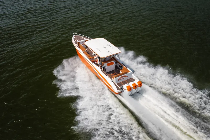 Slide: The Image of Orange and white 2007 Deep Impact 360 C boat speeding on open water. - 54