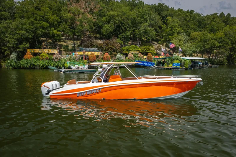The Image of Orange 2007 Deep Impact 360 C boat on a scenic lake with lush greenery. - 2