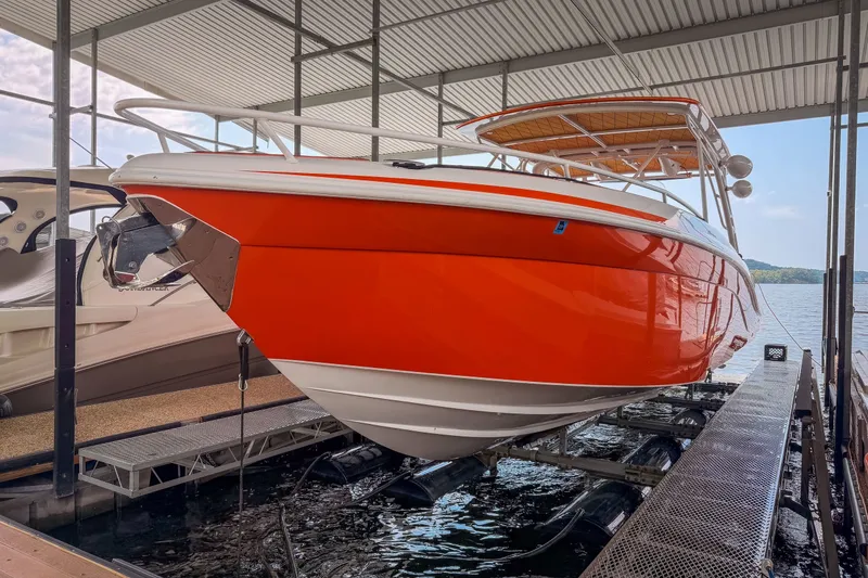 Slide: The Image of Bright orange 2007 Deep Impact 360 C boat docked in a covered marina. - 51