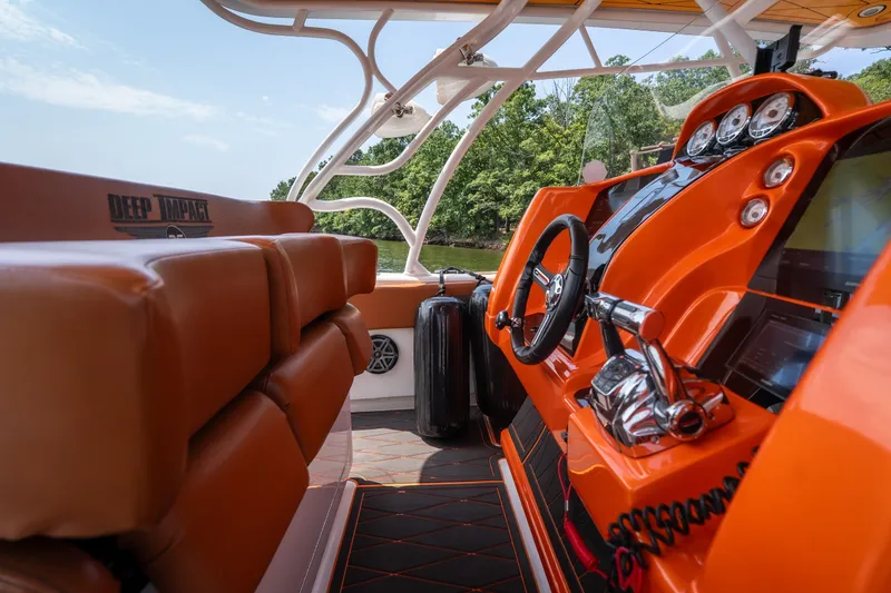 Slide: The Image of Orange interior of 2007 Deep Impact 360 C boat with steering wheel and controls. - 9