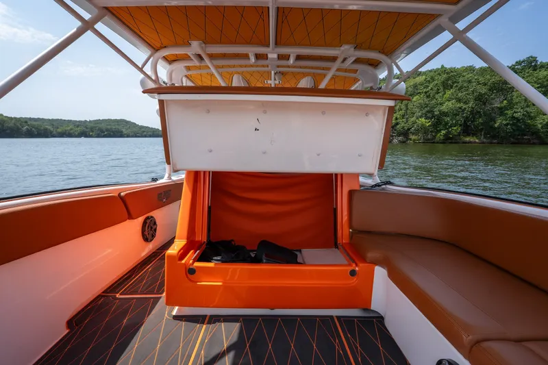 Slide: The Image of 2007 Deep Impact 360 C boat interior with orange seating and storage compartment. - 46