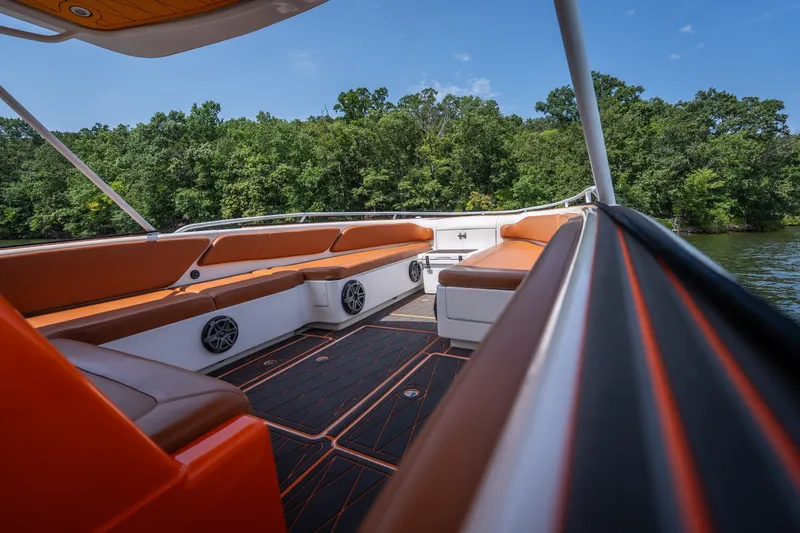 Slide: The Image of 2007 Deep Impact 360 C boat interior with orange seating, on a lake with lush greenery. - 24