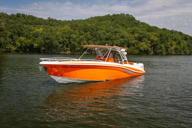 Slide: The Image of Orange 2007 Deep Impact 360 C boat on a serene lake with lush green forest backdrop. - 56