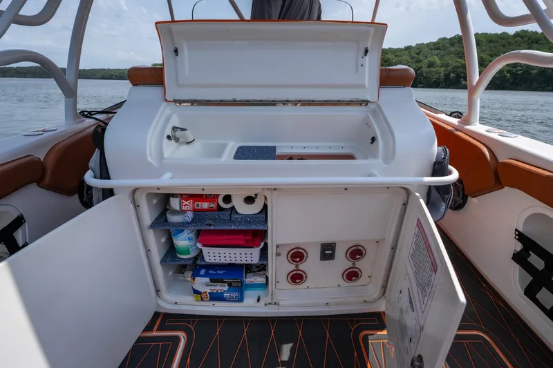Slide: The Image of 2007 Deep Impact 360 C boat interior with open storage compartments and sink. - 22