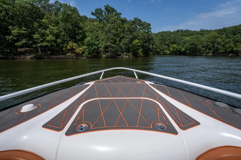 Slide: The Image of Bow view of 2007 Deep Impact 360 C boat on a serene lake with lush greenery. - 27