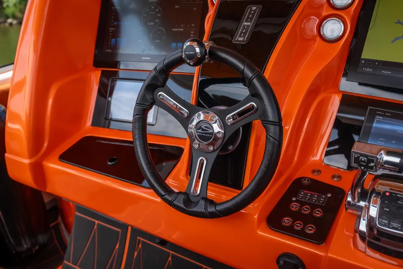 Slide: The Image of Orange dashboard of a 2007 Deep Impact 360 C boat with modern controls and steering wheel. - 12