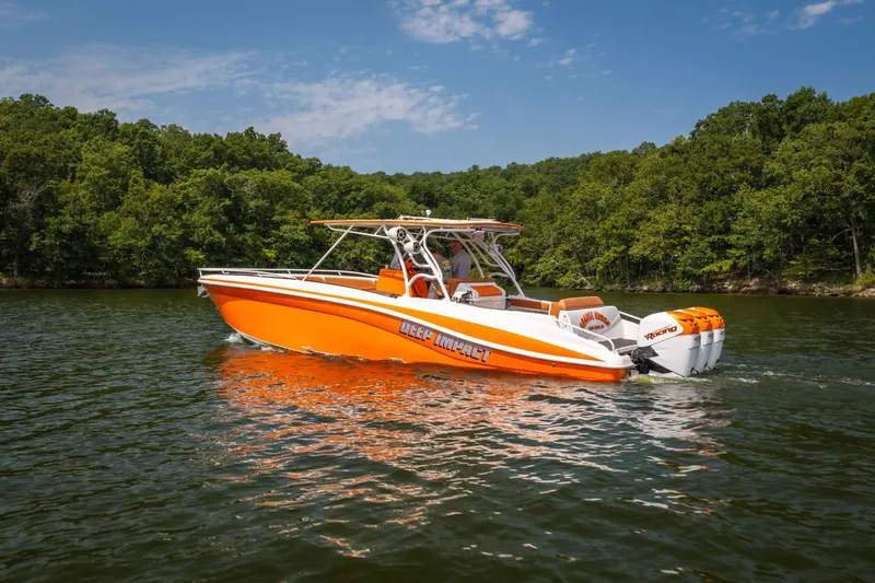 Slide: The Image of Orange 2007 Deep Impact 360 C boat cruising on a lake with forested shoreline. - 3