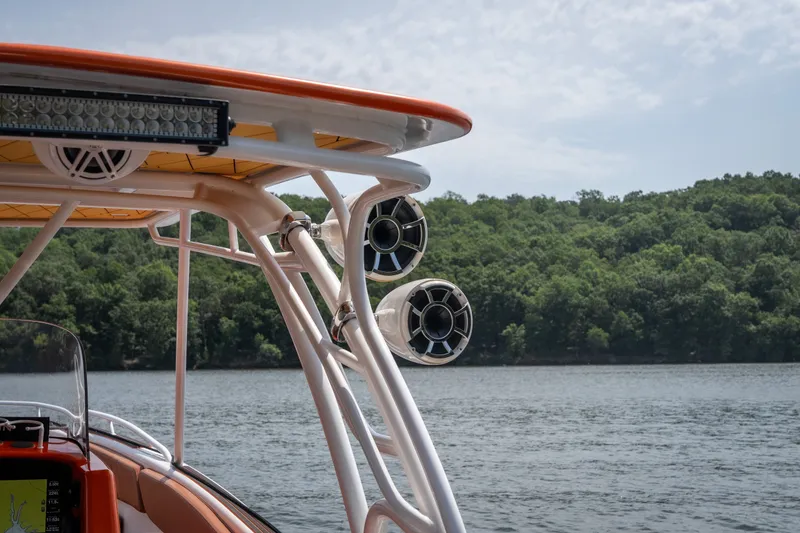 Slide: The Image of 2007 Deep Impact 360 C boat with speakers, on a lake with forested shoreline. - 18