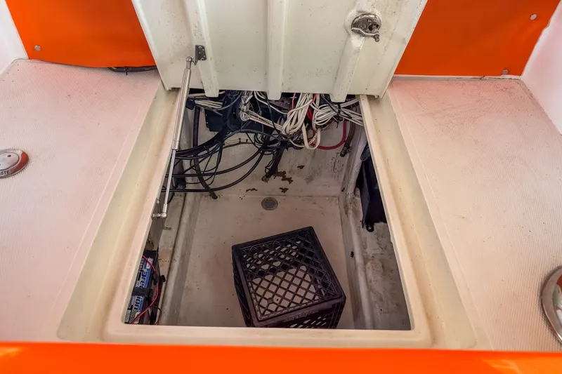 Slide: The Image of Open storage compartment in 2007 Deep Impact 360 C boat, showing wiring and crate. - 47