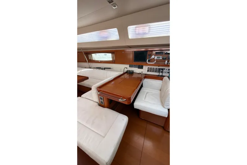 Slide: The Image of Interior of 2013 Beneteau Oceanis 48 yacht with elegant wood finish and white seating. - 4