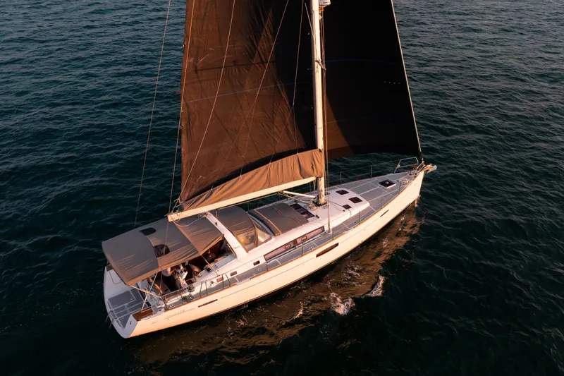 The Image of 2013 Beneteau Oceanis 48 sailing yacht with black sails on open water. - 1