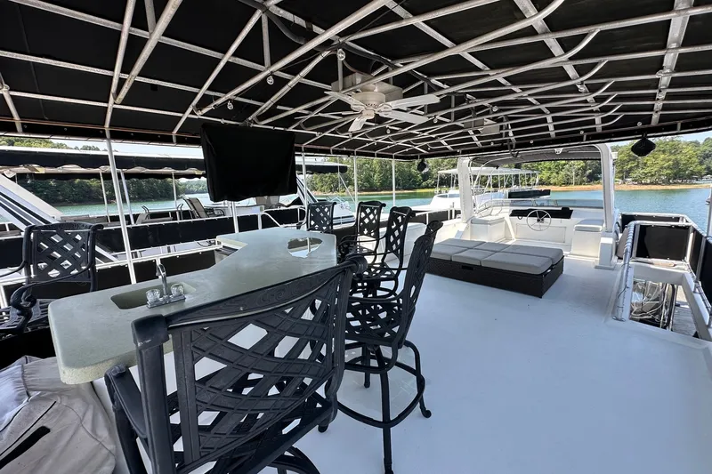 Slide: The Image of Luxurious 2006 Starlite 16x84 houseboat with spacious deck, bar seating, and scenic lake view. - 17