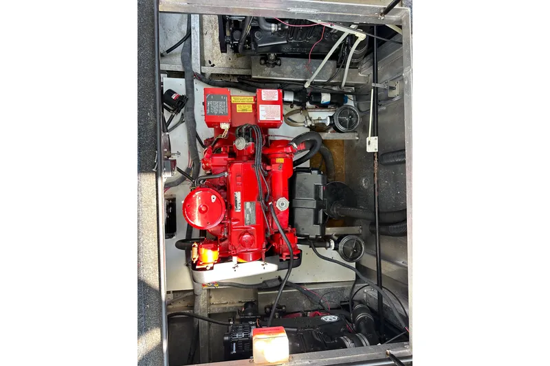 Slide: The Image of Engine compartment of a 2006 Starlite 16x84, featuring a red engine and wiring. - 16