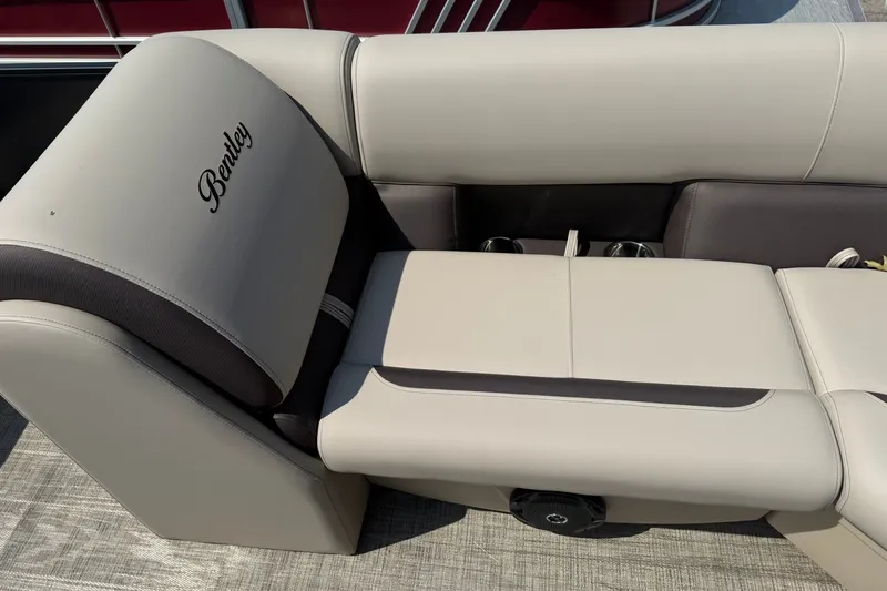 Slide: The Image of 2026 Bentley Pontoons Legacy 223 Swingback seating with beige upholstery and cup holders. - 17