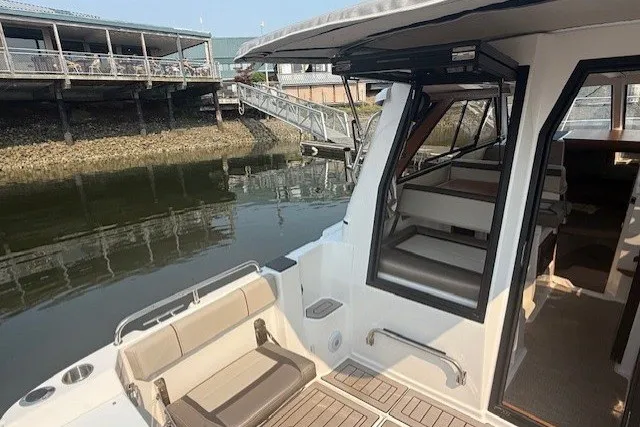 Slide: The Image of 2025 Cutwater C-248 Coupe boat docked, showcasing seating and interior access. - 19