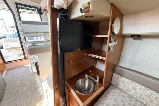 Slide: The Image of 2025 Cutwater C-248 Coupe interior with TV, sink, and seating area. - 14