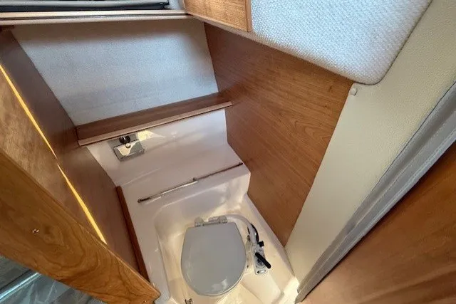 Slide: The Image of 2025 Cutwater C-248 Coupe boat interior bathroom with wooden accents and compact design. - 16