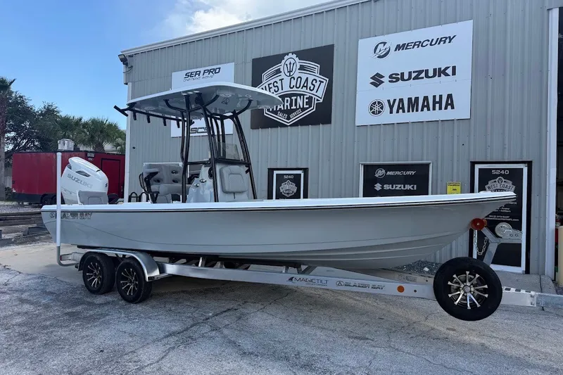 The Image of 2027 Blazer PureBay 2400 boat on trailer outside West Coast Marine dealership. - 1