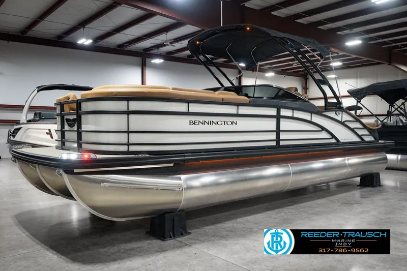 Slide: The Image of 2027 Bennington 23 RSWBA pontoon boat in showroom, featuring sleek design and modern amenities. - 2