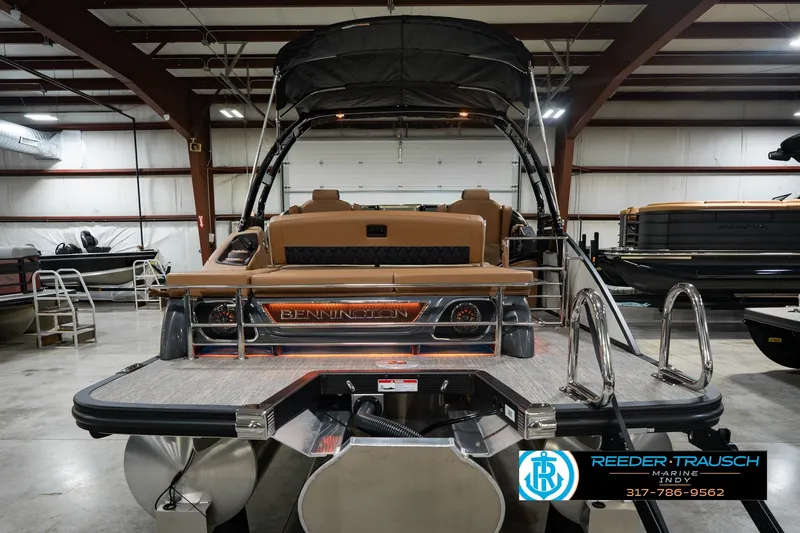 Slide: The Image of 2027 Bennington 23 RSWBA pontoon boat in showroom, rear view with ladder and seating. - 9