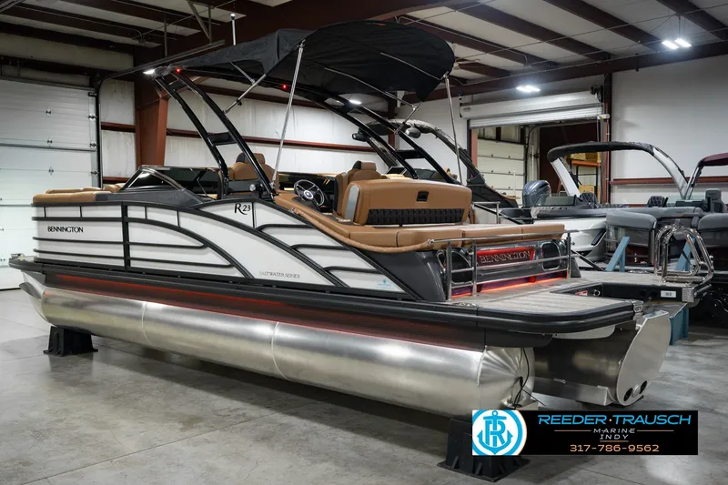 Slide: The Image of 2027 Bennington 23 RSWBA pontoon boat in showroom, featuring sleek design and luxury seating. - 10