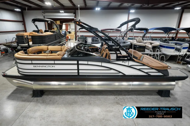 The Image of 2027 Bennington 23 RSWBA pontoon boat in showroom, featuring sleek design and luxurious seating. - 0