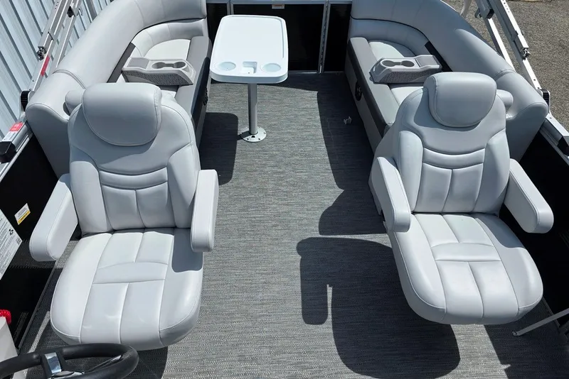 Slide: The Image of 2024 Godfrey Sweetwater 2286 SBC boat interior with plush seating and table setup. - 4