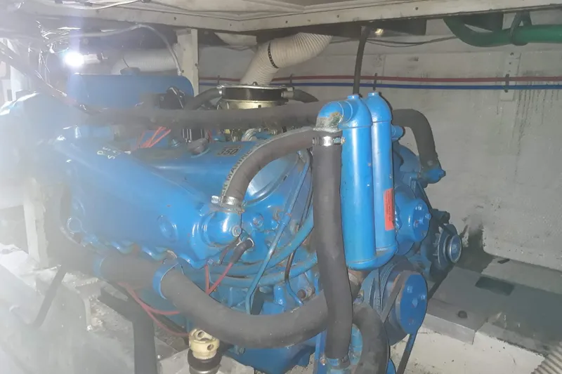 Slide: The Image of Engine room of a 1968 Hatteras 38 Convertible boat, featuring a blue engine. - 21