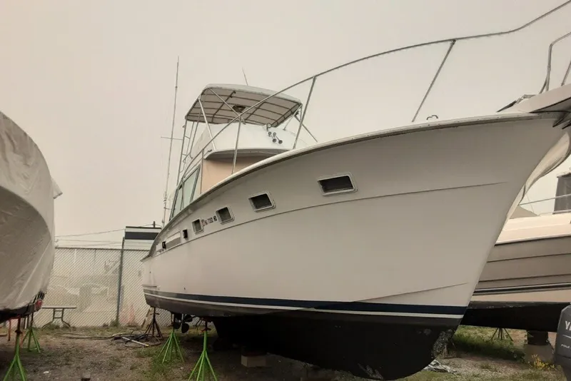 Slide: The Image of 1968 Hatteras 38 Convertible boat on stands, side view, in a storage yard. - 16