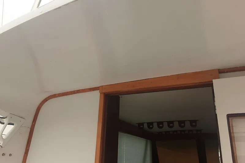 Slide: The Image of Interior view of a 1968 Hatteras 38 Convertible boat, featuring wooden trim and doorway. - 10