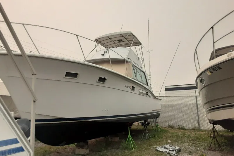 Slide: The Image of 1968 Hatteras 38 Convertible boat on stands in a storage yard. - 17