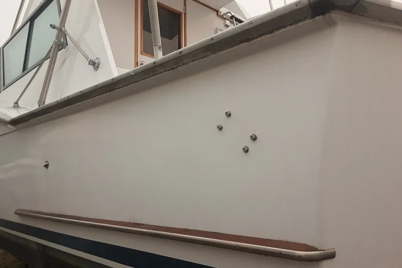 Slide: The Image of 1968 Hatteras 38 Convertible boat side view with railing and window details. - 14