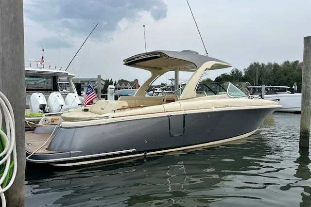 The Image of 2023 Chris-Craft Launch 31 GT boat docked in marina, featuring sleek design and American flag. - 0