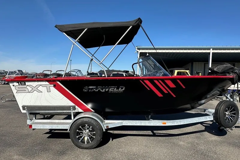 Slide: The Image of 2026 Starweld 18 SXT boat with canopy on trailer, parked outdoors. - 3