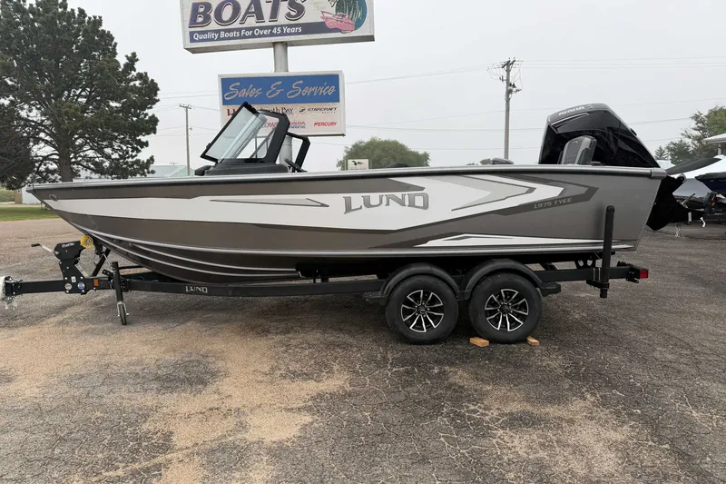 The Image of 2027 Lund 1975 Tyee boat on trailer at dealership, side view. - 1