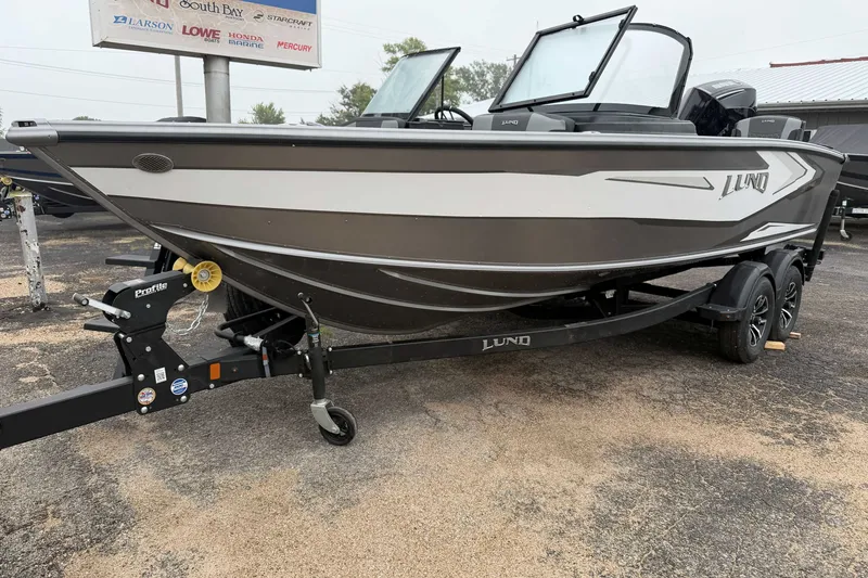 Slide: The Image of 2027 Lund 1975 Tyee boat on trailer, parked outdoors, showcasing sleek design and modern features. - 4