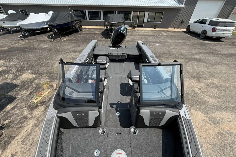 Slide: The Image of 2027 Lund 1975 Tyee boat with open cockpit, parked outdoors near a building. - 15