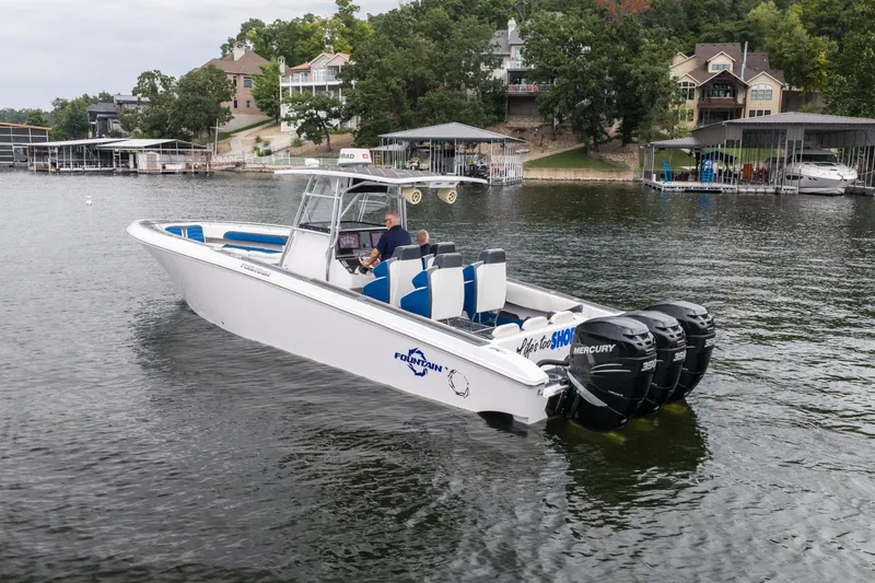 Slide: The Image of 2018 Fountain 38 Center Console boat on a lake with triple Mercury engines. - 2